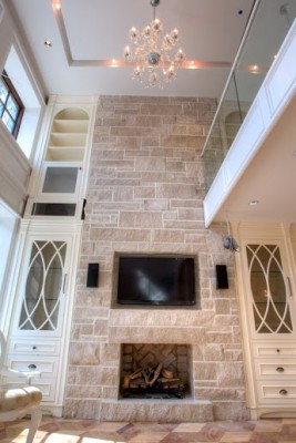 luxury living room with wall mount TV and custom fire place